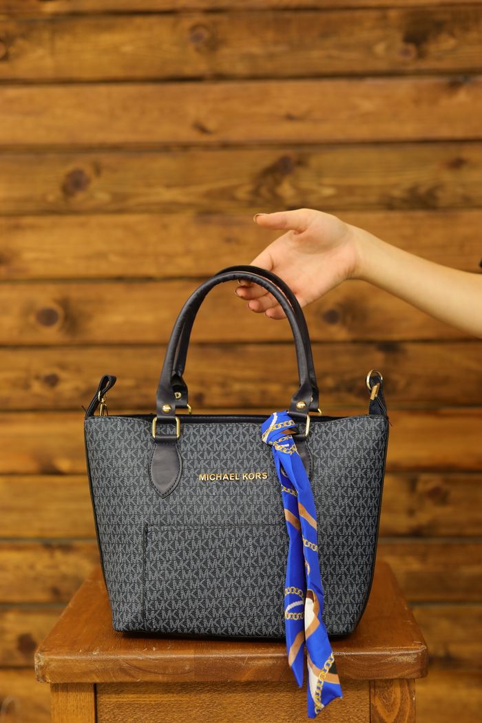 the-story Stylish dark handbag with a vibrant blue scarf, set against a wooden backdrop.